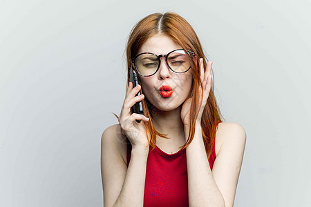拿着手机的红发女人 在她手里用电话交流小玩意细胞嘴唇女孩互联网头发工作女士摄影微笑衣服图片