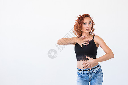 人与时尚概念女人背着她站在摄影机上 用复制空间在白色背景的背后仰视她的肩膀耳环成人牛仔裤女士工作室女性衬衫头发衣服卷曲图片