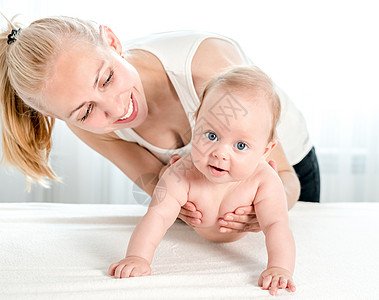 母亲在家抚养和玩儿新生婴儿微笑母性活动童年体操女孩快乐药品训练治疗图片