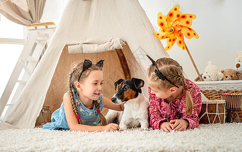 儿童带着狗躺在假浴中闲暇地面猎犬宠物孩子们玩具帐篷微笑乐趣房间图片