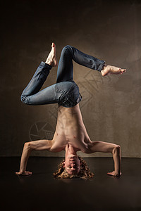 灰色背景的年轻时尚现代舞者芭蕾舞青少年平衡体操成人飞跃灵活性男人特技冒充图片