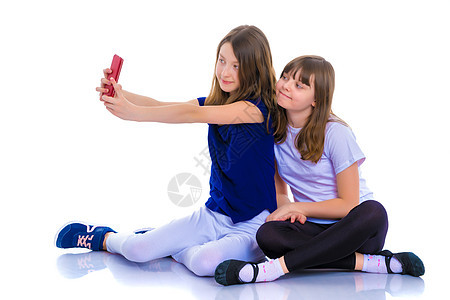 两个女孩用智能手机做自画像童年照片孩子乐趣细胞幸福女孩相机技术快乐背景图片