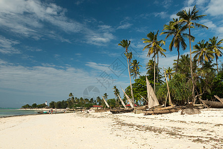 海滩上手工制造的木制渔船木头缆车桅杆情调异国棕榈独木舟热带风景渔夫图片