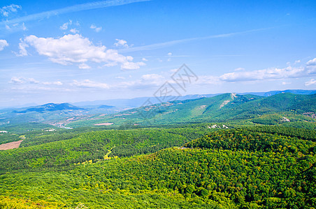 山中的绿草地爬坡蓝色农村太阳场景丘陵晴天白色天空岩石图片