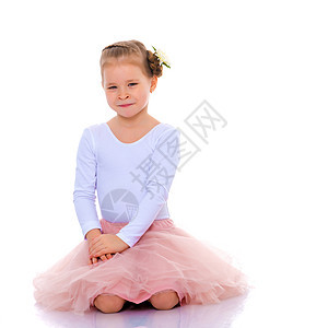 小女孩坐在地板上 她正在睡觉身体童年乐趣女孩白色幸福微笑工作室喜悦裙子图片