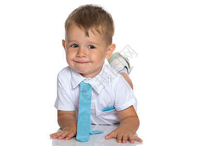 有个小男孩躺在工作室的地板上乐趣儿子喜悦男生说谎青年儿童白色童年金发图片