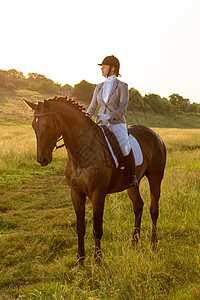 马术运动 年轻女子骑马参加着装高级试练行动女孩晴天竞赛马背骑士皮革马术时尚成人图片