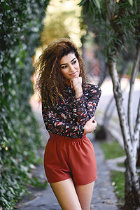 美丽的年轻阿拉伯女人 黑色卷发型的黑卷发爆炸短裤享受卷曲头发黑发女性成人衬衫城市图片