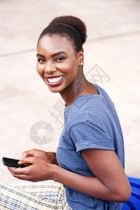 拥有户外移动电话的非洲快乐女青年妇女女性女孩手机微笑技术喜悦幸福闲暇成人黑色图片