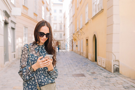 女性在城市里用智能手机说话 在意大利城 年轻有吸引力的旅游者户外活动风景成人讲话女孩旅游太阳镜咖啡店电话旅行照片图片