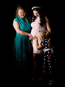 怀孕的年轻女孩与她的母亲和妹妹一起在一个亵渎者身上生活婴儿微笑家庭父母女士成人孩子产妇腹部图片