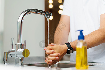 男人在家中水槽中用肥皂洗手浴室打扫镜子卫生男性洗涤公寓棕榈房子家庭图片