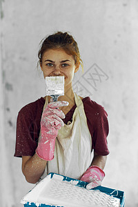 室内装饰房装修中涂刷油漆的女画家女孩工作刷子工人头发检查成人房子房间维修图片