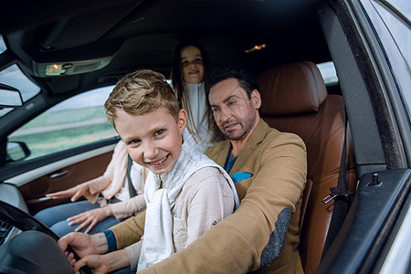 父亲和儿子驾驶汽车男性女性车辆孩子运输女士旅行窗户假期游客图片