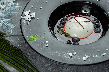 黑盘子里加草莓酱的Panna cotta覆盆子玻璃烹饪奶油蛋糕糖浆明胶叶子薄荷魅力图片