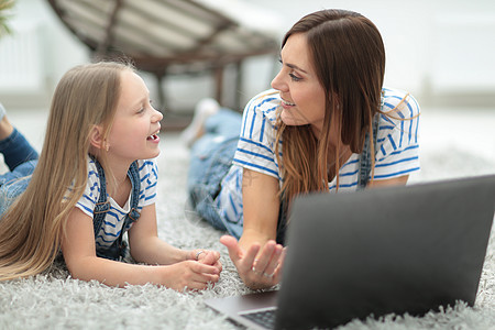 妈妈和小女儿在看笔记本电脑的同时 讨论一些事情女士教学童年公寓成人互联网孩子技术帮助闲暇图片