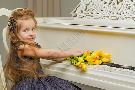 在钢琴旁边的女孩 上面有一束花朵音乐家衣服裙子学习黑发键盘教育艺术学生音乐图片