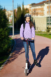 20多岁的年轻女子骑着一辆电动摩托车 使用头盔学生青年成人电池女孩微笑车辆生态快乐女性图片