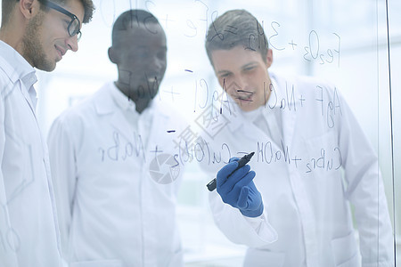 年轻科学家在玻璃板上做笔记器皿专家科学教育男性医生样本解决方案讲话实验图片