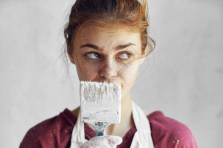 穿着白色围裙 手拿着刷子的女画家微笑房间木头女性女孩拉丁艺术手臂装潢女士图片