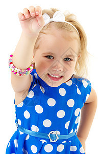 一个小女孩把手镯放在她的手臂上工作室裙子孩子金发微笑女性乐趣黄色项链喜悦图片