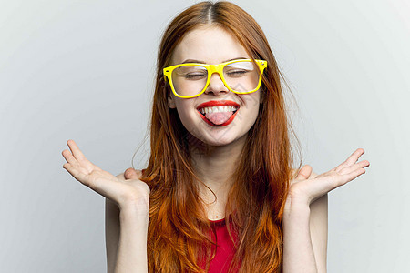 黄色眼镜和红色嘴唇 淡色光底背景衣服女士头发工作室魅力蓝色桌子微笑商业女性图片