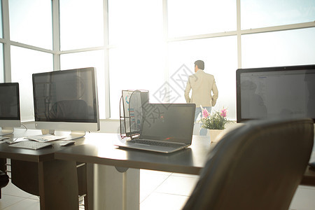 配备办公桌和办公用品的现代办公空间桌面窗户技术椅子屏幕职场笔记本工作地面电脑图片