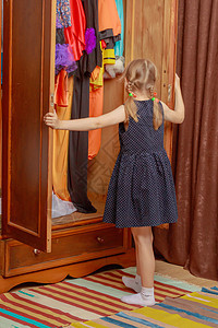 小女孩看衣柜里的样子购物者衣服店铺房间顾客乐趣孩子收藏幸福童年图片