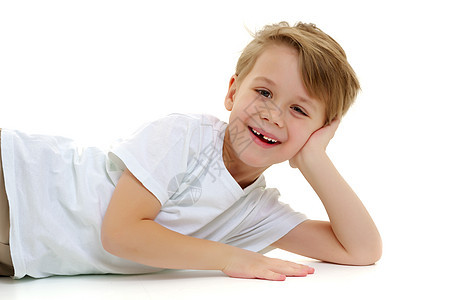 一个小男孩穿着纯白色T恤 笑 情感微笑快乐男性工作室青年喜悦儿童乐趣男生童年图片