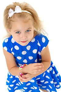 一个小女孩把手镯放在她的手臂上珠宝公主女性童年微笑珠子婴儿幸福工作室黄色图片