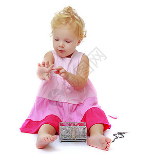 一个小女孩把手镯放在她的手臂上珠子乐趣白色金发幸福珠宝裙子粉色项链黄色图片