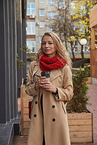 在米花海沟大衣室外 配杯咖啡的女人肖像成人女性城市公共场所杯子围巾闲暇风衣季节外套图片
