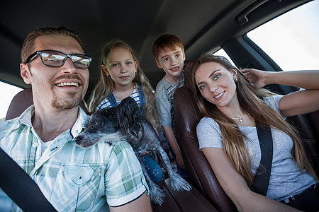 幸福的家属乘坐舒适的汽车旅行运输安全男性孩子父亲车辆乘客座位母亲童年图片