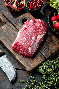 生牛肉片牛排 配有草药和香料 整切柔软的肉片 用铁煎锅 旧黑木桌底图片