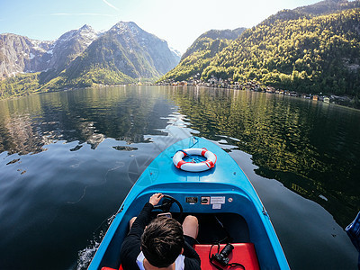 人控制着山湖上的一艘机动艇驾驶运输航行假期旅行血管海洋晴天娱乐水手图片