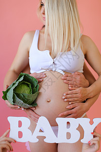 穿着内衣的怀孕金发女郎 留着婴儿和卷心菜图片
