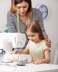 向孩子展示如何在家缝衣的女子学生教育女孩织物玩具女裁缝裁缝娃娃裙子成人图片