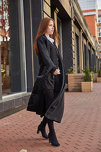 穿着时装的黑大衣在户外行走的红头女孩青年街道城市冒充高跟鞋公共场所建筑女性外套女士图片