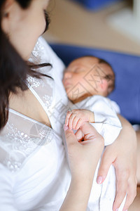年轻母亲穿着白色衣服 怀着新生婴儿图片