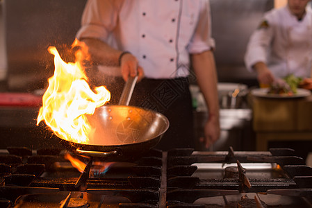 厨师在食物上做烧烤平底锅燃烧盘子炊具油炸餐饮气体美食烹饪行动图片
