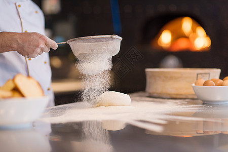 厨师面粉洒满新鲜比萨饼面团烘烤滚动男性厨房手工面包食物桌子乡村烹饪图片