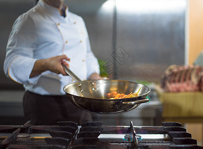 厨师在食物上做烧烤行动平底锅气体燃烧午餐厨房火炉服务烤箱盘子图片