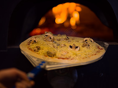 厨师把美味的比萨饼放在砖木烤炉上壁炉面团烧伤美食餐厅石头食物火焰推杆厨房图片