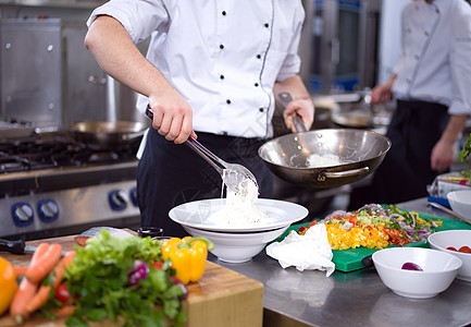 服务意大利面的厨师双手桌子蔬菜勺子面条食物午餐食谱草药椭圆形餐厅图片