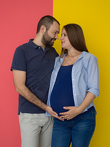 在多彩背景下被孤立的怀孕夫妇肚子工作室父亲母性婴儿家庭成人夫妻妻子男人图片