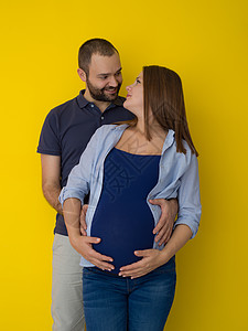 宝宝妈妈在黄色背景下被孤立的怀孕夫妇女士父母家庭妈妈男人肚子夫妻丈夫身体母性背景