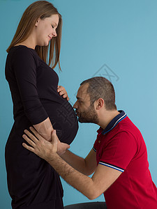 在蓝背景下被隔离的怀孕夫妇工作室女性男性丈夫母性生活肚子蓝色男人父亲图片