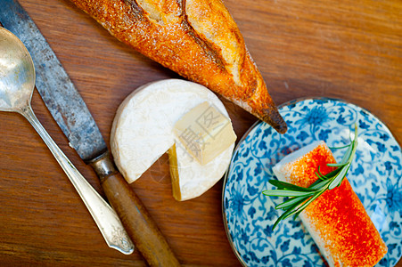 法国奶酪和木切割机上新鲜的法国乳酪和面包包营养产品迷迭香摄影桌子作品红辣椒辣椒食物拼盘图片