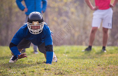 美美足球运动员在行动手套大学游戏专注头盔训练力量男人场地成功图片