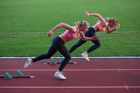 女运动员在田径赛道上奔跑训练男人身体乐趣竞争女孩们赛跑者行动挑战女性图片